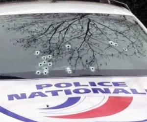 La luna de un coche de la policía tiroteado durante el ataque contra la sede del semanario satírico Charlie Hebdo en París. (Foto: AFP).
