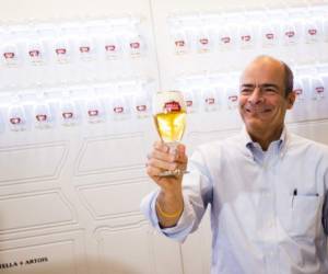 Brewery group Anheuser-Busch InBev CEO Carlos Brito poses with a glass of Stella Artois beer during a press conference on the company's 2017 year results in Leuven, on March 1, 2018.AB InBev, the world's biggest brewer, on March 1 posted a huge jump in net profit for last year, drinking in the synergies from its blockbuster acquisition of rival SABMiller in 2016. / AFP PHOTO / Belga / JASPER JACOBS / Belgium OUT