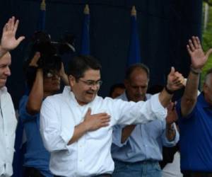 Honduran President Juan Orlando Hernandez (C) announces his decision to apply for another period in office, in Tegucigalpa on November 6, 2016. President Juan Orlando Hernandez said Sunday he will seek re-election in 2017, reigniting debate on a single-term limit that has deeply divided the country and led to a previous president's ouster. / AFP PHOTO / ORLANDO SIERRA