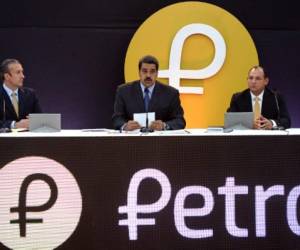 Nicolás Maduro conversa con el vicepresidente Tarek El Aissami y el ministro de Ciencia y Tecnología Hugbel Roa durante el lanzamiento del Petro. Foto AFP.