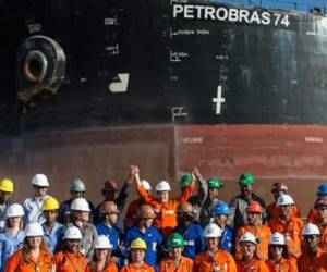 La presidenta brasileña Dilma Rousseff (C) posa junto a trabajadores de la estatal petrolera Petrobras durante una visita a la compañía. (Foto: AFP)