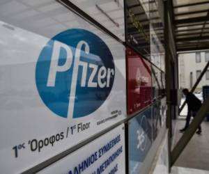A man entry at the building where Pfizer's office located in Thessaloniki on November 10, 2020. - Pfizer stock surged higher on November 9, 2020 prior to the opening of Wall Street trading after the company announced its vaccine is '90 percent effective' against Covid-19 infections. The news cheered markets worldwide, especially as coronavirus cases are spiking, forcing millions of people back into lockdown. (Photo by Sakis MITROLIDIS / AFP)