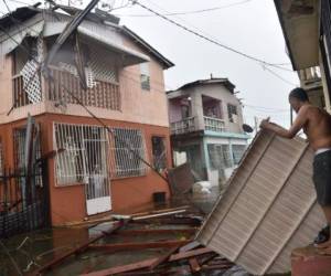 Residentes de San Juan, Puerto Rico, recuperan algo de entre los escombros de sus viviendas afectadas por el huracán María. El ciclón abatió a la isla con vientos de 240km/h. AFP PHOTO / Hector RETAMAL