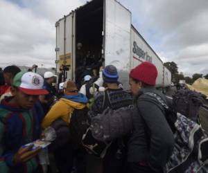 Migrants from poor Central American countries -mostly Hondurans- moving towards the United States in hopes of a better life or to escape violence, get in the back of a truck on the outskirts of Mexico City as they continue their trek north, on November 10, 2018. - The United States embarked Friday on a policy of automatically rejecting asylum claims of people who cross the Mexican border illegally in a bid to deter Central American migrants and force Mexico to handle them. (Photo by Alfredo ESTRELLA / AFP)