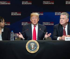 US President Donald Trump speaks alongside US Representative Peter King (R), Republican of New York, and Evelyn Rodriguez (L), whose daughter was killed by MS-13 gang members, during a roundtable discussion on immigration at Morrelly Homeland Security Center in Bethpage, New York, May 23, 2018. / AFP PHOTO / SAUL LOEB