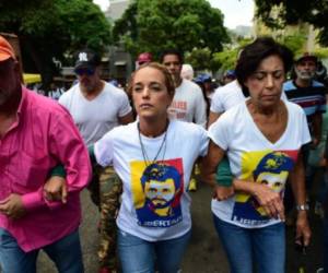 Lilian Tintori, wife of jailed opposition leader Leopoldo Lopez (C) and Lopez's mother, Antonieta Mendoza de Lopez (R) lead a protest march in Caracas on April 26, 2017.Protesters in Venezuela plan a high-risk march against President Maduro Wednesday, sparking fears of fresh violence after demonstrations that have left 26 dead in the crisis-wracked country. / AFP PHOTO / RONALDO SCHEMIDT