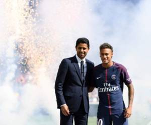Neymar (R) posa con el presidente del PSG, el catarí Nasser Al-Khelaifi, durante la presentación del futbolista como nuevo jugador del equipo el 5 de agosto de 2017.