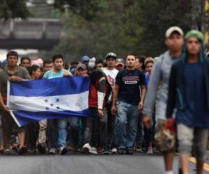 Honduran migrants heading in a caravan to the United States, walk in direction to Tecun Uman -the border with Mexico,- as they leave Guatemala City, on October 18, 2018. - US President Donald Trump threatened Thursday to send the military to close its southern border if Mexico fails to stem the 'onslaught' of migrants from Central America, in a series of tweets that blamed Democrats ahead of the midterm elections. (Photo by ORLANDO SIERRA / AFP)