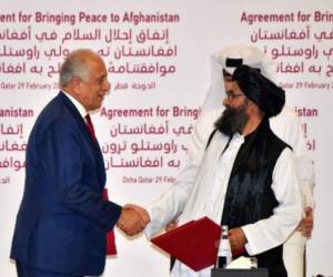 (L to R) US Special Representative for Afghanistan Reconciliation Zalmay Khalilzad and Taliban co-founder Mullah Abdul Ghani Baradar shake hands after signing a peace agreement during a ceremony in the Qatari capital Doha on February 29, 2020 - The United States signed a landmark deal with the Taliban, laying out a timetable for a full troop withdrawal from Afghanistan within 14 months as it seeks an exit from its longest-ever war. (Photo by Giuseppe CACACE / AFP)