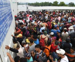 Honduran migrants taking part in a caravan to the US wait to cross to Mexico, in Ciudad Tecun Uman, Guatemala, on October 20, 2018. - Thousands of migrants who forced their way through Guatemala's northwestern border and flooded onto a bridge leading to Mexico, where riot police battled them back, on Saturday waited at the border in the hope of continuing their journey to the United States. (Photo by ORLANDO SIERRA / AFP)