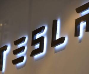 (FILES) A file picture taken on February 8, 2018 shows the logo of US car maker Tesla in Brussels. - They are everywhere: in our smartphones, our tablets, in pacemakers. But it is in the automotive sector, a sector in full transformation, that electric batteries represent a real challenge in the face of the energy transition. (Photo by Emmanuel DUNAND / AFP)