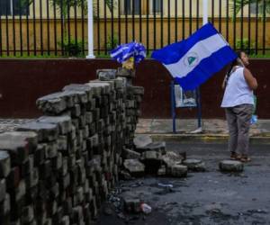 Un mujer sostiene una bandera de Nicaragua cerca de una barricada en Monimbo, Masaya, a 35 kilómetros de Managua. AFP PHOTO / Inti OCON