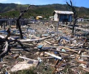Debris remaining in pond and destruction from 1998 Hurricane Mitch in Savanna Bight village Guanaja Bay Islands Honduras