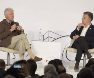 Former US President Bill Clinton (L) speaks beside Colombian President Juan Manuel Santos during the World Coffee Producers Forum in Medellin, Colombia on July 11, 2017. / AFP PHOTO / JOAQUIN SARMIENTO