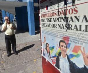 Un hombre observa un puesto de periódico que muestran la ventaja del candidato opositor Salvador Nasralla en Tegucigalpa, Honduras, el 27 de noviembre de 2017. AFP PHOTO / Rodrigo ARANGUA