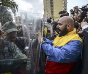El diputado opositor, Marco Bozo, se enfrenta con antmotines de la Guardia Nacional en Caracas, en una nueva serie de choques tras la decisión de la Corte Suprema de anular al Congreso. Foto/AFP