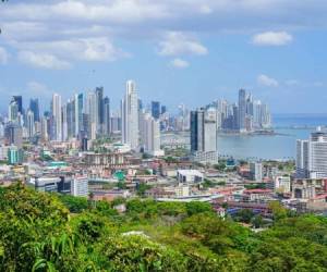 Panama City, Panama - February 12, 2017: Top view of Panama City with its skyscrapers from Ancon hill, the highest hill in Panama City. To the view point there is 30 min. hiking through remains of with city isolated Jungle. In front is green jungle and on top of photo is blue sky with white clouds. Panama City is the financial and shipping hub of Central America.