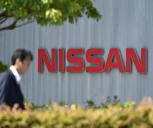 (FILES) This file photo taken on May 11, 2017 shows a man walking in front of the logo of Japan's Nissan Motor Corporation at its global headquarters in Yokohama, Kanagawa prefecture.Nissan said on July 9, 2018 it had found falsification of data on emissions and fuel efficiency for cars made at almost all its plants in Japan. / AFP PHOTO / Kazuhiro NOGI