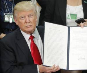 President Donald Trump holds up an executive order for border security and immigration enforcement improvements after signing the order during a visit to the Homeland Security Department headquarters in Washington, Wednesday, Jan. 25, 2017. (AP Photo/Pablo Martinez Monsivais) Trump Homeland