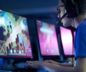 Team of Professional eSport Gamers Playing in Competitive MMORPG/ Strategy Video Game on a Cyber Games Tournament. They Talk to Each other into Microphones. Arena Looks Cool with Neon Lights.
