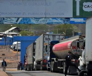 Trucks remain in line as they wait to enter Nicaragua at the crossing point in Guasaule, Honduras on May 13, 2020. - Honduran authorities have reinforced security measures in the border with Nicaragua to prevent the crossing of Nicaraguan citizens possibly infected with COVID-19. (Photo by ORLANDO SIERRA / AFP)