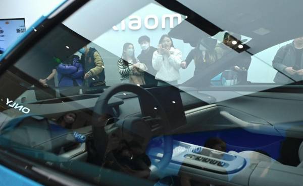 <i>La gente mira un automóvil eléctrico Xiaomi SU7 exhibido en una tienda Xiaomi en Beijing el 26 de marzo de 2024. FOTO WANG Zhao / AFP</i>
