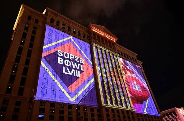 <i>Los logotipos de fútbol americano del Super Bowl LVIII de la NFL se proyectan en el costado del hotel y casino Caesars Palace Las Vegas de Caesars Entertainment, Inc. antes del Super Bowl LVIII en Las Vegas, Nevada, el 7 de febrero de 2024. FOTO Patrick T. Fallon / AFP</i>
