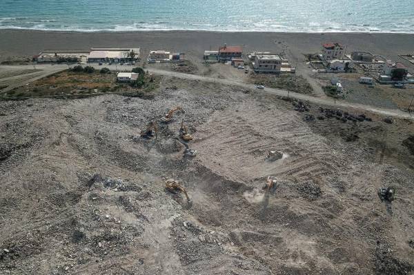 <i>Esta fotografía aérea tomada el 9 de julio de 2023 muestra excavadoras trabajando en un vertedero junto a una playa en Samandag, en el sur de la provincia de Hatay. La excavadora destrozó los restos del edificio dañado en el sureste de Turquía, derribándolos en una nube de polvo, la última amenaza que enfrentan los sobrevivientes del mortal terremoto de febrero que devastó la región. Extendiéndose hasta el horizonte, un capullo de fino polvo gris envuelve la ciudad de Samandag, en el sur de la provincia de Hatay, que fue devastada por el terremoto del 6 de febrero que mató a más de 55.000 personas y arrasó partes de Turquía y Siria.OZAN KOSE / AFP</i>