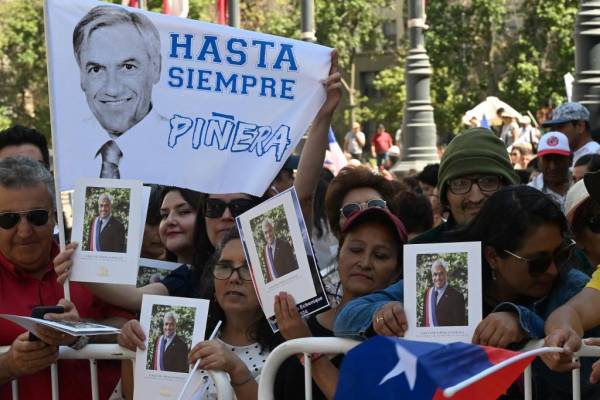 <i>Los partidarios del difunto expresidente de Chile, Sebastián Piñera, se reúnen frente a La Moneda para presentar sus últimos respetos durante el funeral de estado de Piñera en Santiago, el 9 de febrero de 2024. Foto de RODRIGO ARANGUA/AFP</i>
