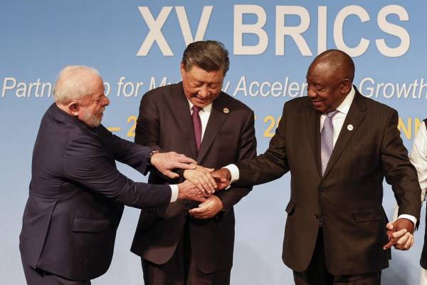 <i>(De izquierda a derecha) El presidente de Brasil, Luiz Inácio Lula da Silva, el presidente de China, Xi Jinping, y el presidente sudafricano, Cyril Ramaphosa, hacen un gesto durante la Cumbre BRICS de 2023 en el Centro de Convenciones de Sandton en Johannesburgo el 23 de agosto de 2023. (Foto de GIANLUIGI GUERCIA / PISCINA / AFP)</i>