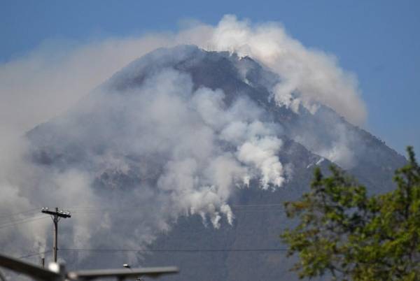 <i>El humo surge de los incendios forestales en las laderas del volcán de Agua, visto desde Villa Nueva, Guatemala, el 22 de febrero de 2024. Un voraz incendio forestal arrasa las laderas del inactivo volcán de Agua, cerca de la capital de Guatemala, sin víctimas o evacuaciones reportadas hasta el momento. FOTO Johan ORDÓÑEZ / AFP</i>
