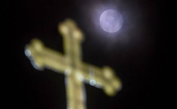 <i>Esta fotografía tomada el 25 de marzo de 2024 muestra una Luna Llena sobre una cruz en la Iglesia de San Juan Bautista en Skopje. FOTO Robert ATANASOVSKI / AFP</i>