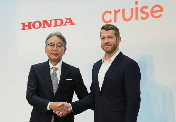 <i>El presidente de Honda Motor, Toshihiro Mibe (izq.), le da la mano al director ejecutivo de Cruise, Kyle Vogt (der.), durante una conferencia de prensa para anunciar un servicio de conducción autónoma en Tokio el 19 de octubre de 2023. FOTO STR / JIJI PRESS / AFP</i>