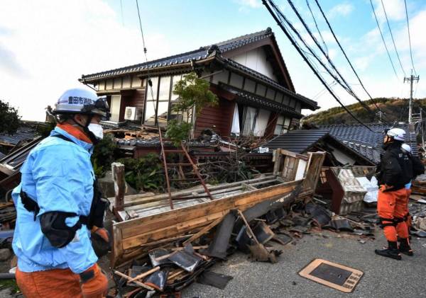 <i>Los bomberos inspeccionan casas de madera derrumbadas en Wajima, prefectura de Ishikawa, el 2 de enero de 2024, un día después de que un gran terremoto de magnitud 7,5 sacudiera la región de Noto en la prefectura de Ishikawa por la tarde. FOTO Kazuhiro NOGI/AFP</i>