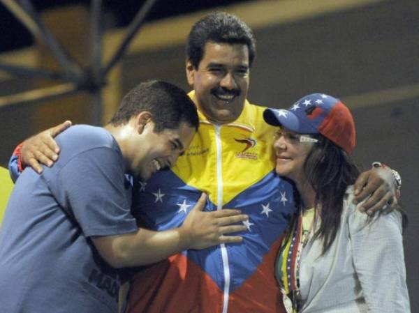(FILES) In this file photo taken on April 06, 2013, Venezuelan acting President Nicolas Maduro (C) embraces his wife Cilia Flores (L) and son Nicolas Maduro during a campaign rally in Puerto Ordaz, Bolivar state, Venezuela. - The US imposed sanctions on June 28, 2019, on the son of Venezuelan President Nicolas Maduro for serving in his father's 'illegitimate regime.''Maduro relies on his son Nicolasito and others close to his authoritarian regime to maintain a stranglehold on the economy and suppress the people of Venezuela,' US Treasury Secretary Steven Mnuchin said in announcing the action. (Photo by Juan BARRETO / AFP)