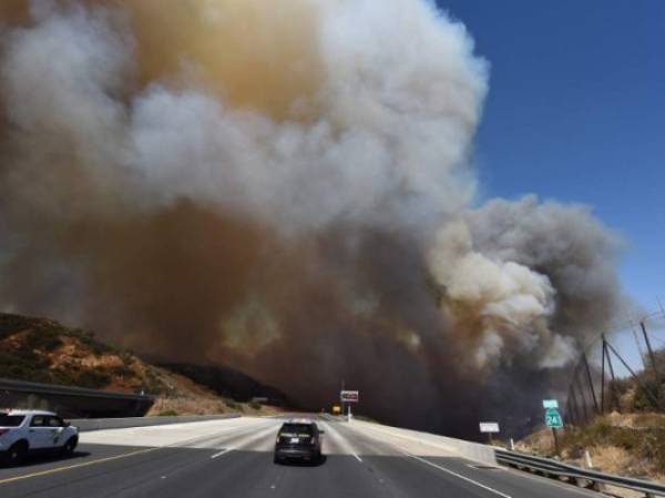 Una patrulla bloquea la autopista 241 por la densidad del humo que sale de uno de los incendios que azotan a California.