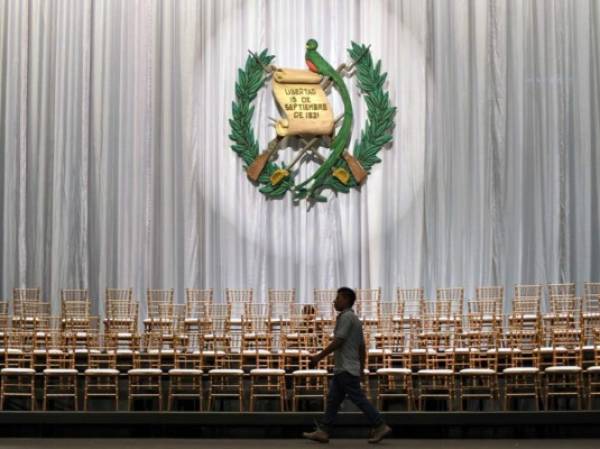 An employee walks past chairs during preparations for Guatemalan President-elect Alejandro Giammattei's swearing-in ceremony at the National Theater, in Guatemala City, on January 13, 2020. - Giammattei will take over on Tuesday as president of Guatemala until 2024 with the challenge of resuming governance to face poverty and corruption, as well as deciding whether to accept Mexicans who are asking for asylum in the United States. (Photo by Orlando ESTRADA / AFP)