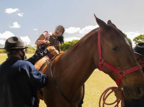 Miembros de la policía montada de Costa Rica ayudan a la paciente María Lourdes Valverde con equinoterapia en San José, el 23 de marzo de 2021. - Los caballos de apoyo emocional ayudan a las personas a sobrellevar las condiciones de salud física y mental en una instalación de la policía montada en Costa Rica. (Foto de Ezequiel BECERRA / AFP)