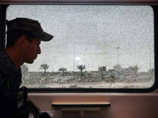 Un policía iraquí junto a la ventanilla rota de un tren en Bagdad el 14 de junio de 2014. (Foto: AFP)