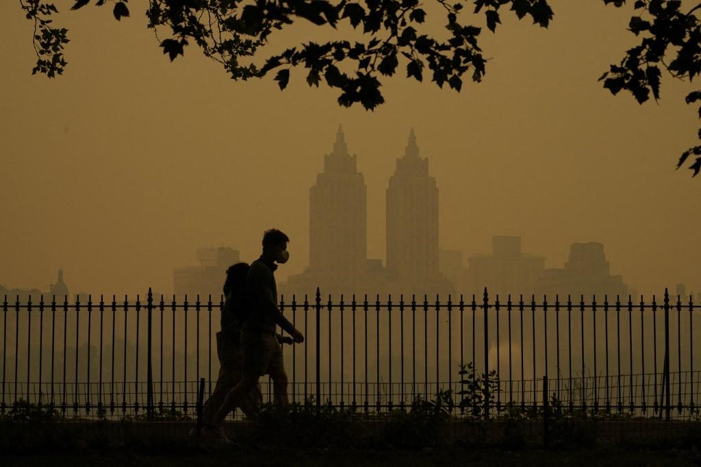 <i>La gente camina en Central Park mientras el humo de los incendios forestales en Canadá causa condiciones de niebla en la ciudad de Nueva York el 7 de junio de 2023. El humo de los incendios forestales de Canadá ha envuelto las regiones del noreste y el Atlántico medio de los EE. UU., lo que genera preocupación sobre los daños del aire pobre persistente calidad. (Foto de TIMOTEO A. CLARY / AFP)</i>