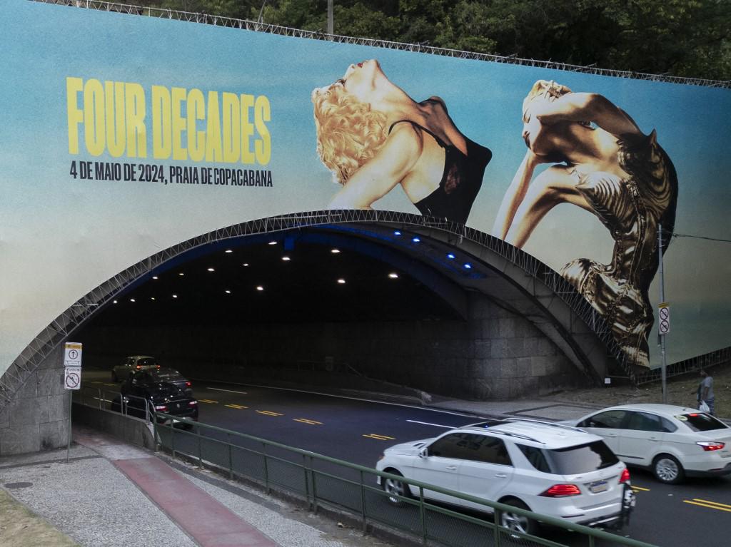 <i>Un anuncio del espectáculo de la estrella del pop estadounidense Madonna se muestra en el túnel de Leme en Río de Janeiro, Brasil, el 3 de mayo de 2024, en vísperas de un mega concierto gratuito para cerrar su gira 'Celebration'. (Foto de Pablo PORCÍUNCULA/AFP)</i>