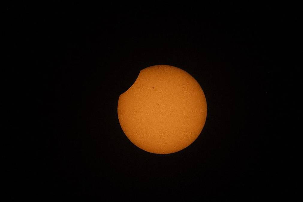 <i>La luna cruza frente al sol durante el eclipse solar anular en Bogotá el 14 de octubre de 2023. (Foto de Juan BARRETO / AFP)</i>