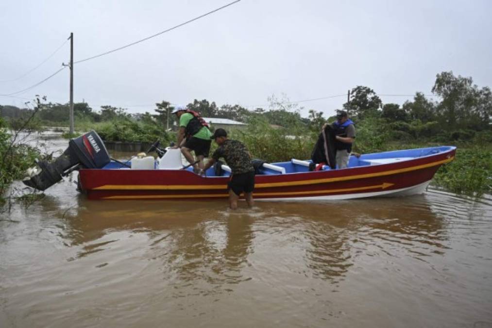 Residents board a boat in a flooded area due to the heavy rains caused by Hurricane Eta, now degraded to a tropical storm, at Las Posas village in Morales, Izabal, 220 km north Guatemala City on November 5, 2020. - At least four people, including two children, died in landslides as tropical storm Eta swept through Guatemala, civil protection officials said Thursday. The deaths brought the toll in Central America to eight after Eta tore into northern Nicaragua as a Category 4 hurricane on Tuesday causing mudslides that killed two miners, as well as two young girls in neighboring Honduras. (Photo by Johan ORDONEZ / AFP)