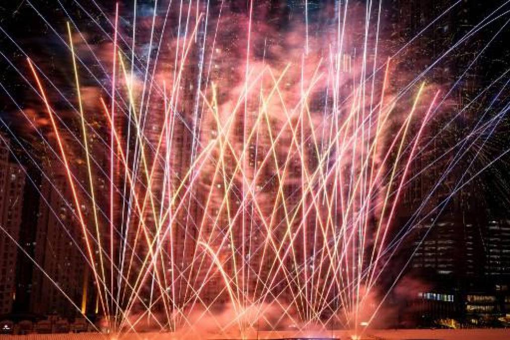 <i>Se lanzan fuegos artificiales desde el techo de un centro comercial rodeado de apartamentos para celebrar el Año Nuevo en Yakarta el 1 de enero de 2023. (Foto de Yasuyoshi CHIBA / AFP)</i>