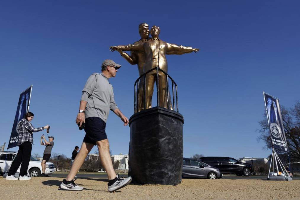 Unas personas pasan junto a una estatua, creada por artistas anónimos, representa a Epstein y Trump en una pose similar a la que popularizó Jack y Rose en la película "Titanic". EFE/EPA/WILL OLIVER