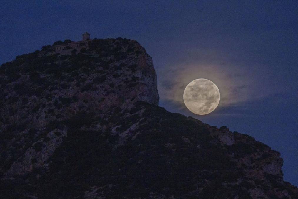 PALMA, 07/10/2025.- Puesta de la primera luna llena de octubre, también llamada 'luna de cosecha', esta madrugada en el poniente mallorquín. EFE/CATI CLADERA