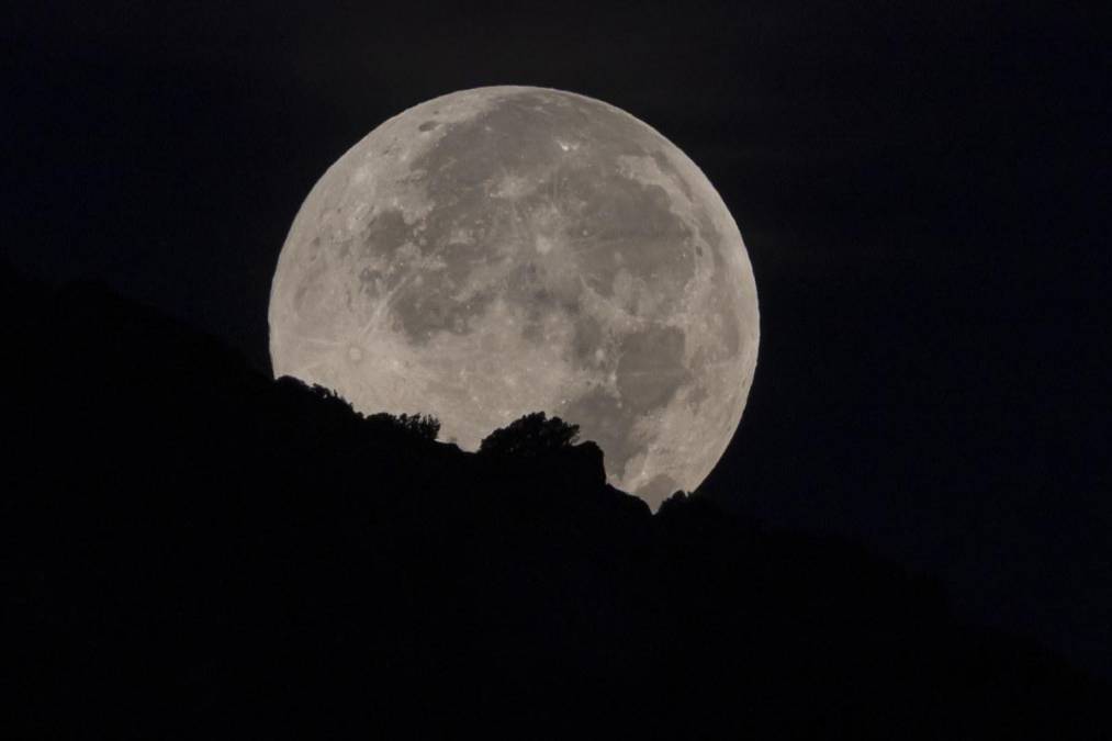 PALMA, 07/10/2025.- Puesta de la primera luna llena de octubre, también llamada 'luna de cosecha', esta madrugada en el poniente mallorquín. EFE/CATI CLADERA