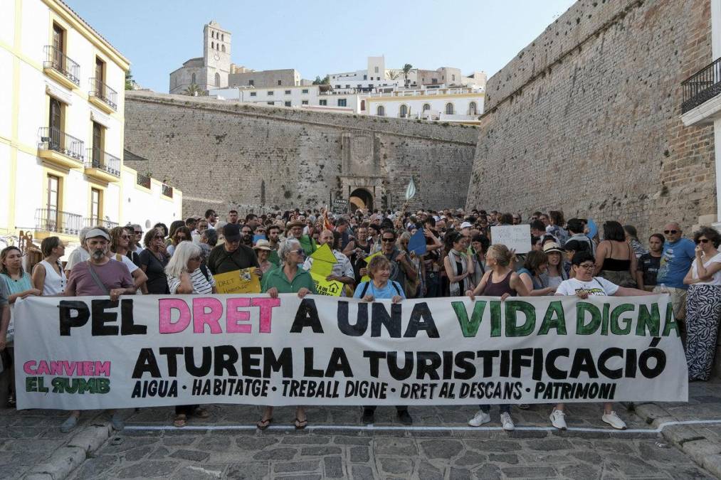 <i>Manifestación convocada por 'Caviem el rumb' contra la masificación turística este domingo, en Ibiza (Islas Baleares). Miles de personas se manifestaron este domingo en varias ciudades españolas como Barcelona, Palma, San Sebastián y Granada contra el turismo masivo, un modelo que, según denuncian, expulsa a los vecinos de los barrios y dispara el precio de la vivienda. EFE/ Sergio G. Canizares</i>
