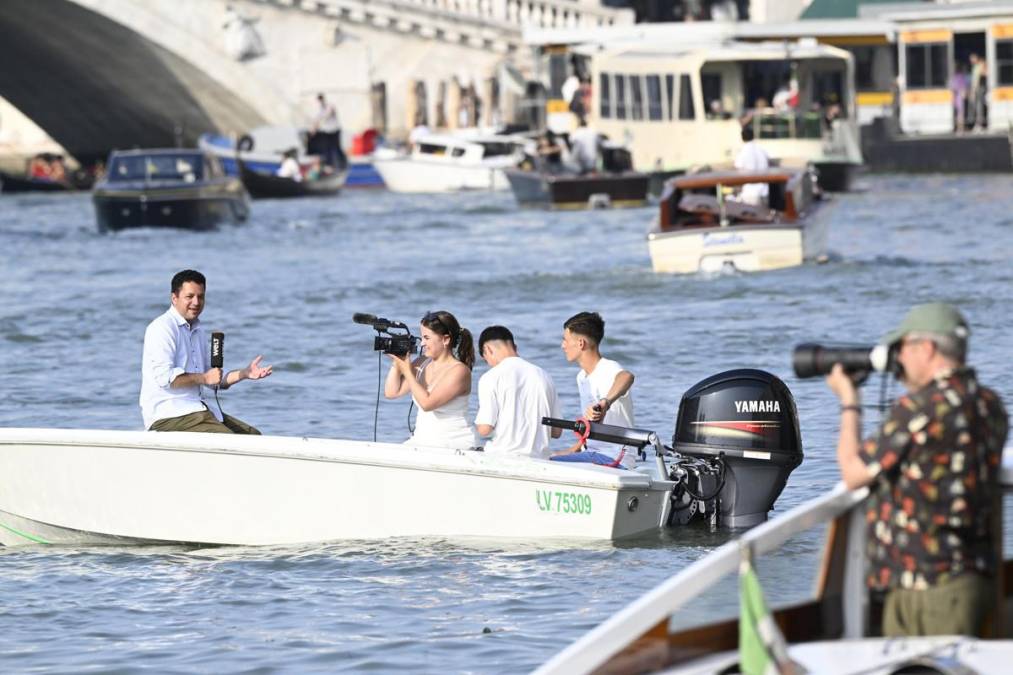 <i>Un periodista en una pequeña embarcación realiza una transmisión televisiva en directo junto al Hotel Aman, donde se aloja el multimillonario de Amazon, Jeff Bezos, en Venecia, Italia, el 26 de junio de 2025. El multimillonario tecnológico estadounidense Bezos y su prometida, la presentadora de televisión Lauren Sanchez, habrían invitado a unos 200 invitados a su boda en la ciudad italiana. (Italia, Venecia) EFE/EPA/DANIEL DAL ZENNARO</i>