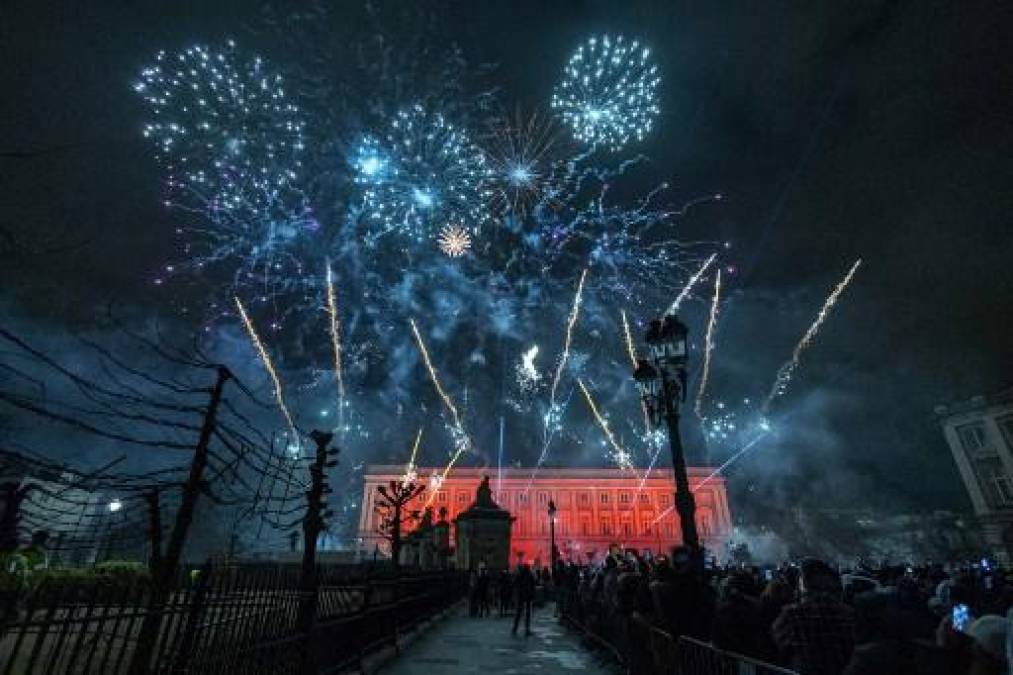 <i>Los juerguistas ven los fuegos artificiales durante las celebraciones del Año Nuevo, en Bruselas el 1 de enero de 2024. (Foto de NICOLAS MAETERLINCK / Belga / AFP) </i>